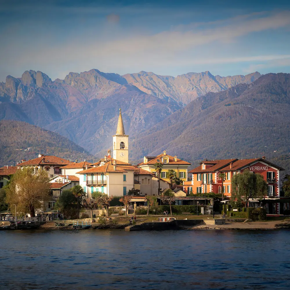 Vista luminosa di un borgo italiano tra mare, colline e terrazze panoramiche
